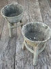 A pair of vintage 1950s French rustic planters with a patinated finish, displayed on a wooden surface.