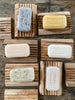 Rectangular french soaps on top of rectangular olive wood, ridged soap holders.