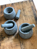 unpolished grey granite pestle and mortar, pictured crushing spices.